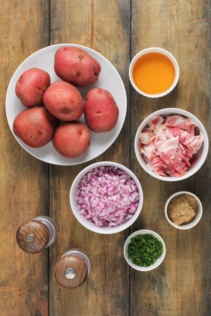 Ingredients for german potato salad on a wooden table.