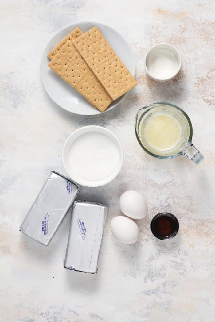 Ingredients for mini cheesecakes arranged on a countertop.