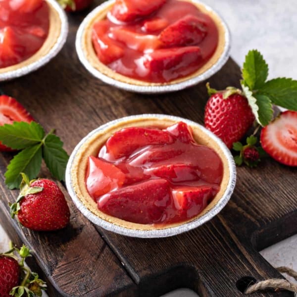 Mini graham cracker crusts filled with strawberry pie filling.