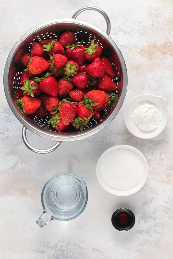 Ingredients for strawberry pie filling arranged on a light-colored countertop.