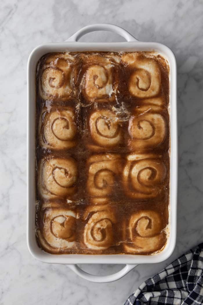 Tiktok cinnamon rolls, aka cinnamon rolls with heavy cream, assembled and ready to be baked in a white baking dish.