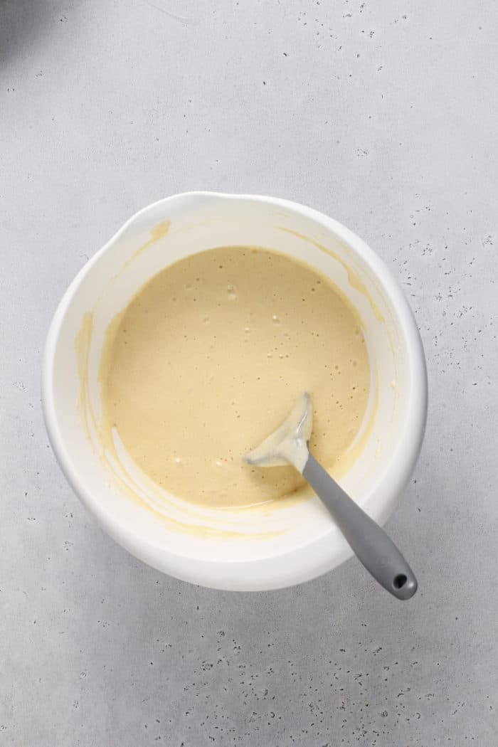 Batter for a yellow sponge cake in a white mixing bowl.