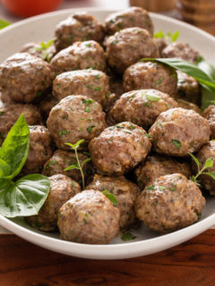 White bowl filled with baked homemade meatballs.