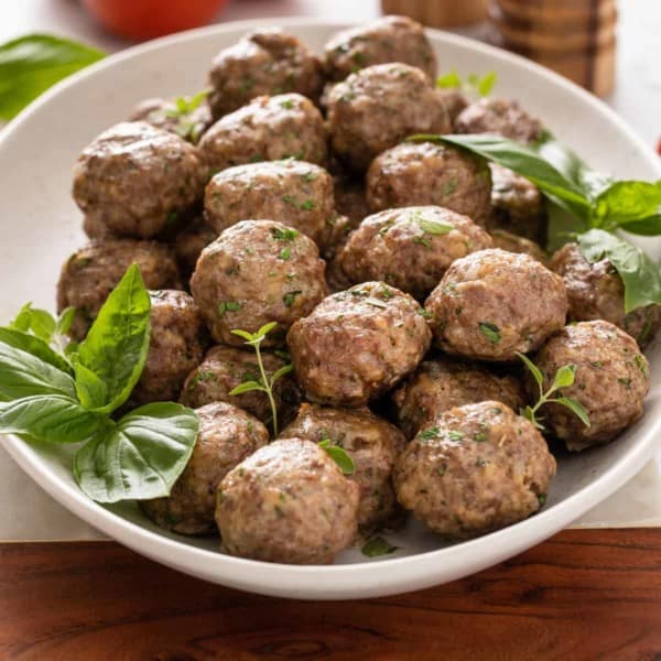 White bowl filled with baked homemade meatballs.