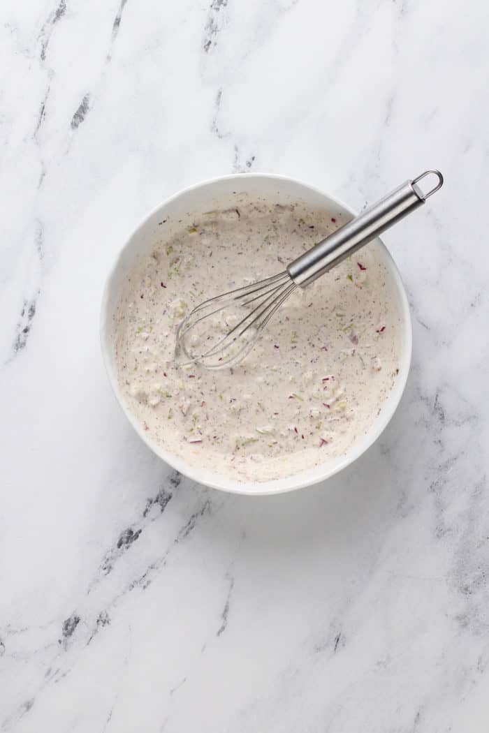 Grinder sandwich dressing whisked together in a white bowl.