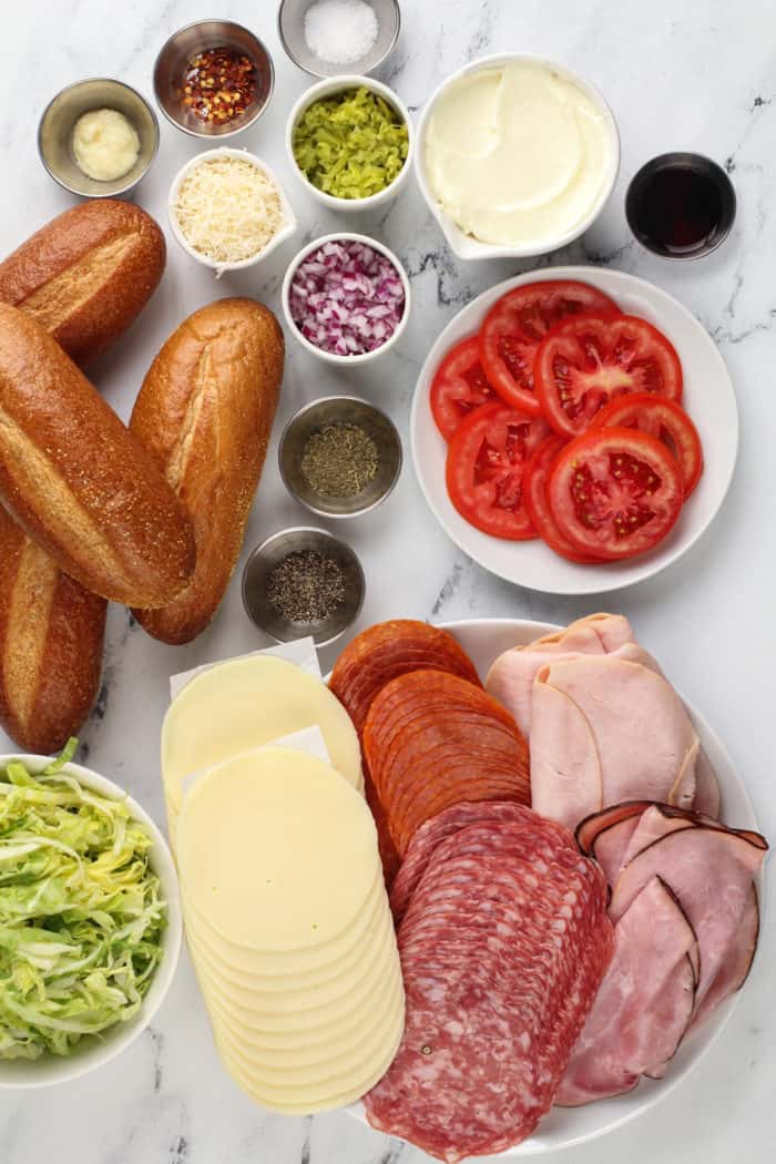 Ingredients for the tiktok grinder sandwich arranged on a marble countertop.