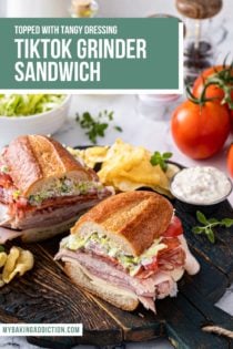 Halved grinder sandwich set on a wooden serving board next to potato chips and a ramekin of the sandwich dressing. Text overlay includes recipe name.