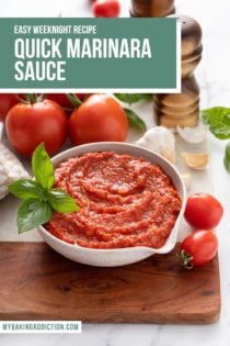 White bowl filled with marinara sauce, set on a wooden and marble board and surrounded by tomatoes and basil. Text overlay includes recipe name.