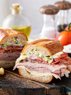 Slices of grinder sandwich on a wooden serving board.