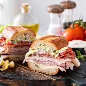 Slices of grinder sandwich on a wooden serving board.