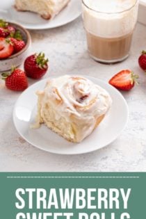 Strawberry roll topped with cream cheese frosting set on a white plate, with coffee and fresh strawberries in the background. Text overlay includes recipe name.