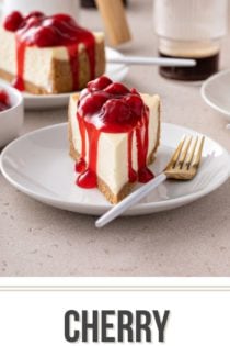 Slice of cherry cheesecake on a white plate, facing the camera. A second slice is visible in the background. Text overlay includes recipe name.