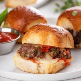 Close up of meatball slider on a white plate.