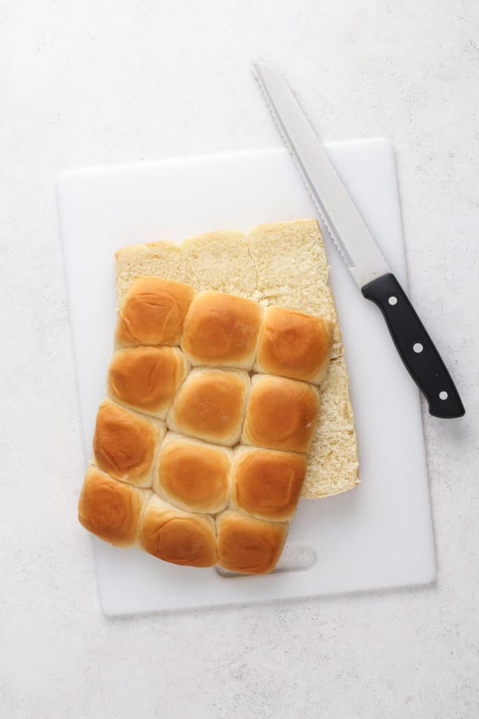 Hawaiian rolls cut in half on a cutting board.