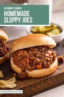Close up of a sloppy joe sandwich on a wooden cutting board. A bowl of pickles is visible in the background. Text overlay includes recipe name.