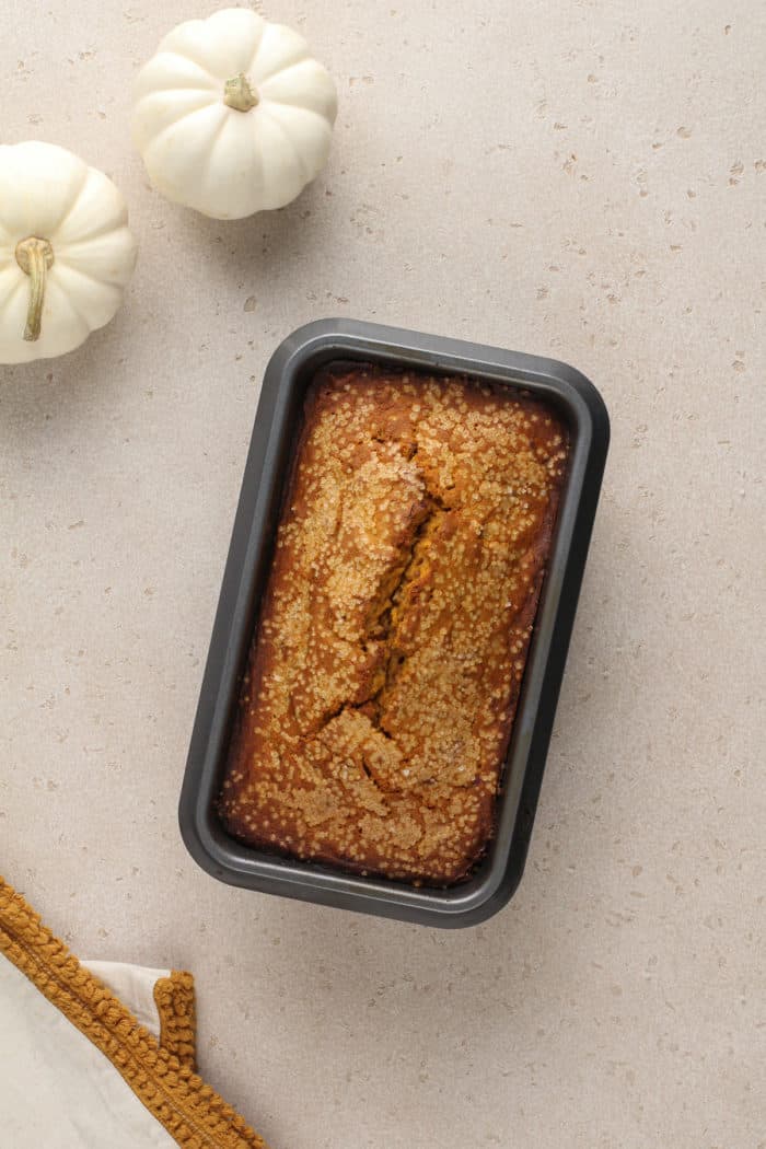 Overhead view of a baked loaf of brown butter pumpkin bread on a countertop.