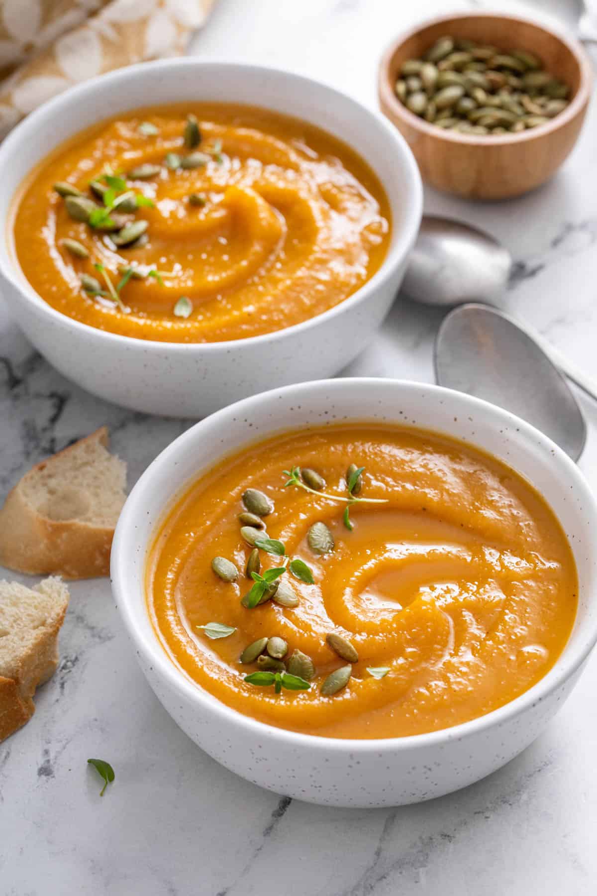 pumpkin seeds and thyme on top of butternut squash soup