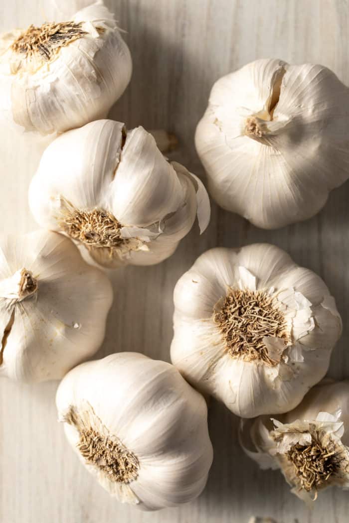 Several heads of garlic on a light countertop.