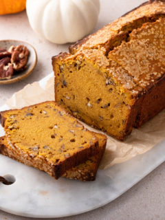 Sliced loaf of brown butter pumpkin bread on a marble board.