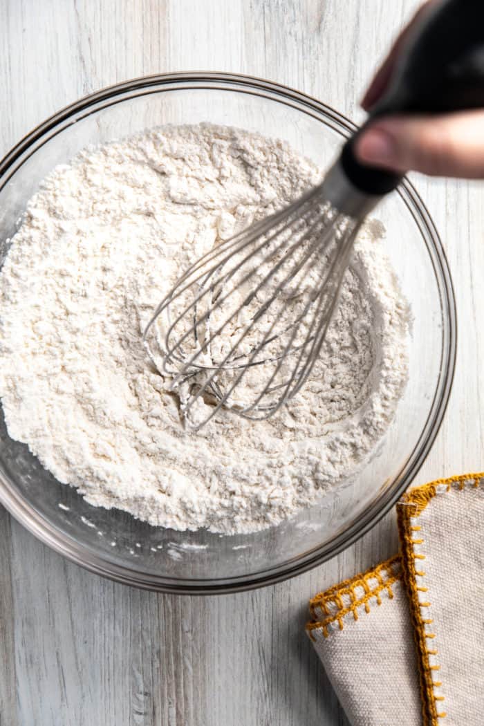 Cake flour substitute being whisked together in a glass bowl.