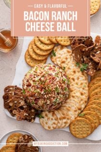 Overhead view of bacon ranch cheese ball surrounded by crackers on a white platter. Text overlay includes recipe name.