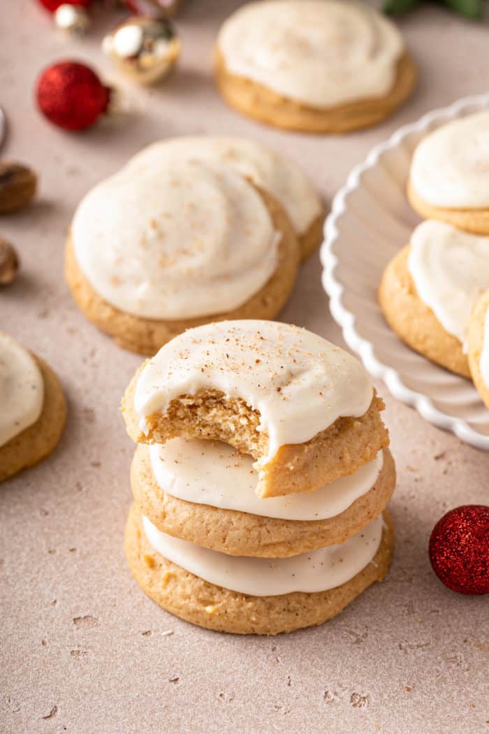 Three stacked eggnog cookies. The top cookie has a bite taken out of it.