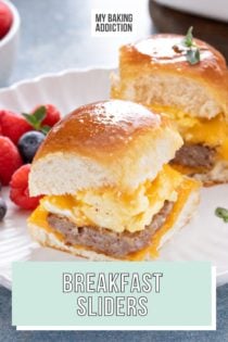 White plate with two breakfast sliders and mixed fresh berries on it. Text overlay includes recipe name.