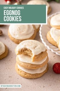 Three stacked eggnog cookies. The top cookie has a bite taken out of it. Text overlay includes recipe name.