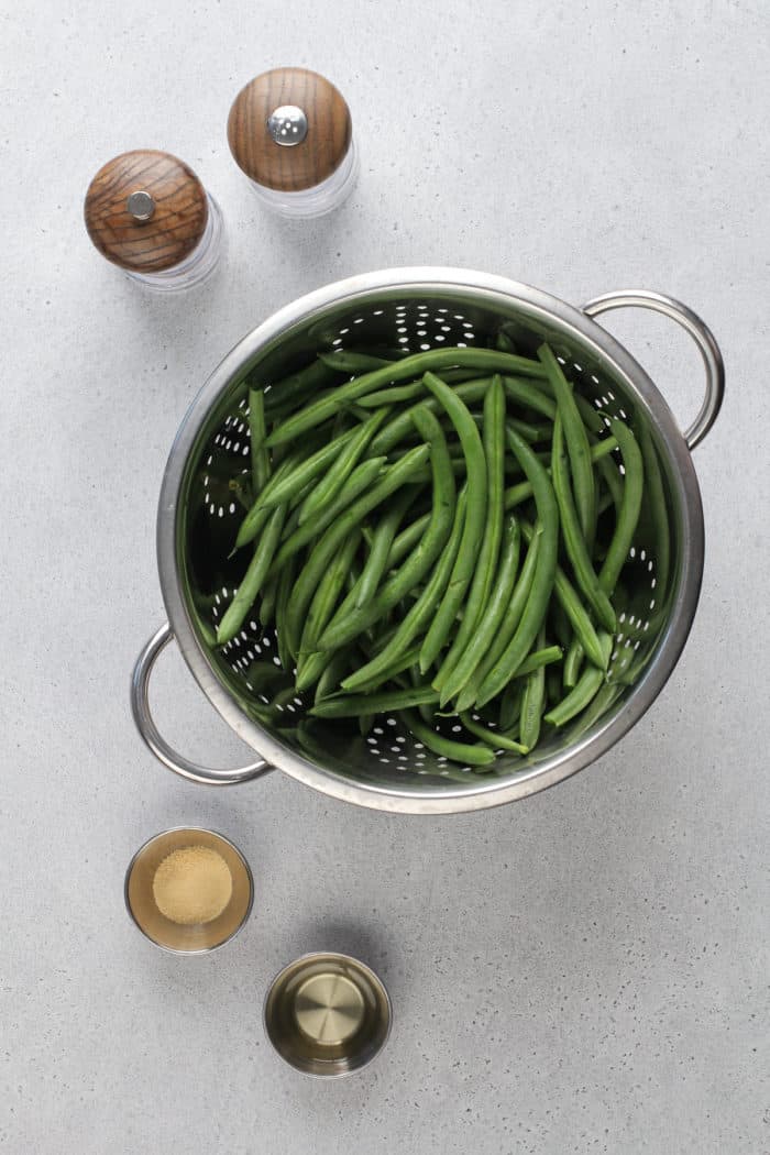 Ingredients for air fryer green beans on a gray countertop.