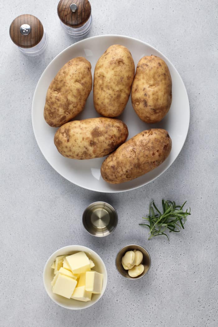 Ingredients for hasselback potatoes on a gray countertop.