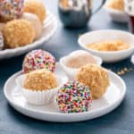 Assorted peanut butter balls on a white plate.