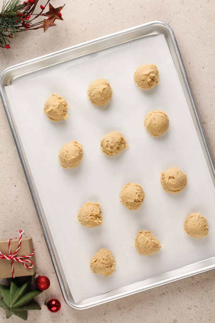 Unbaked eggnog cookie dough portioned onto a parchment-lined baking sheet.