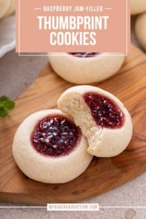 Three raspberry thumbprint cookies arranged on a wooden board. One of the cookies has a bite taken out of it. Text overlay includes recipe name.