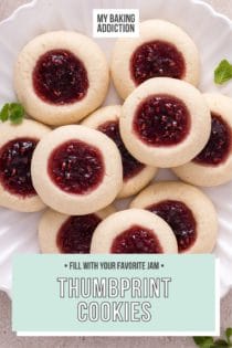Overhead view of raspberry jam-filled thumbprint cookies piled onto a white plate. Text overlay includes recipe name.