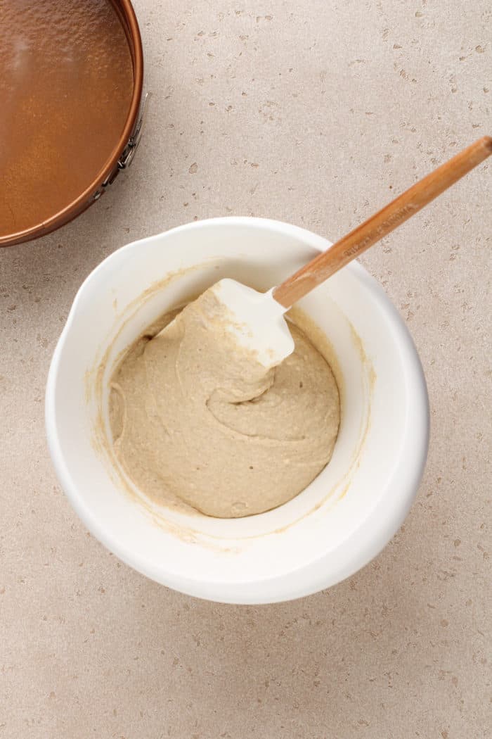 Bisquick coffee cake batter being stirred in a white mixing bowl.