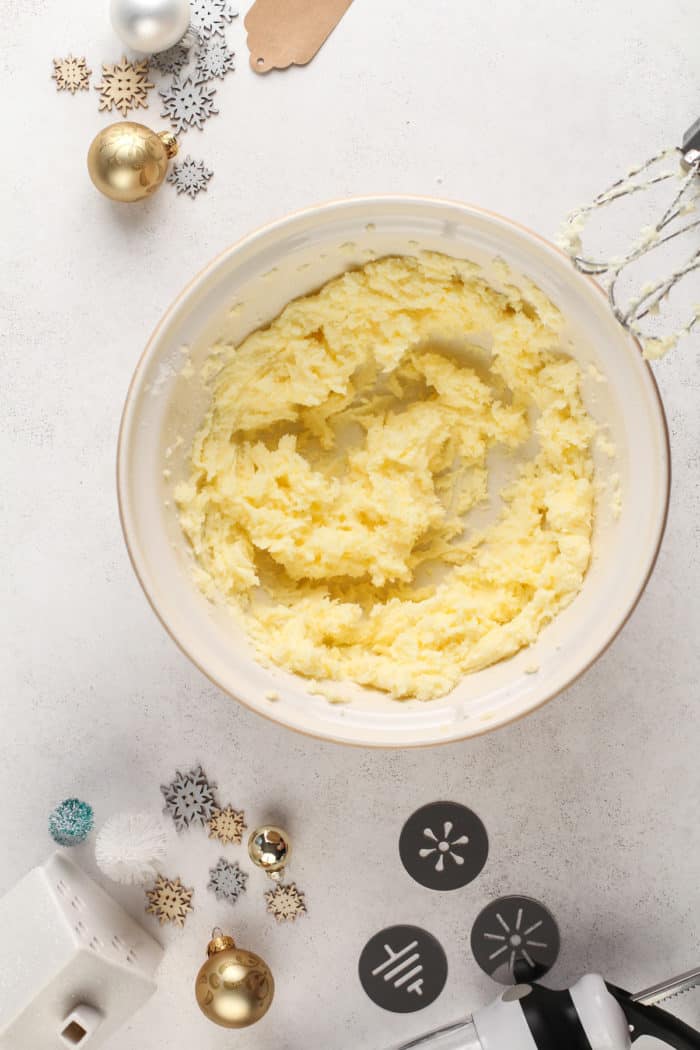 Butter and sugar creamed in a ceramic mixing bowl.