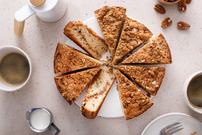 Overhead view of sliced Bisquick coffee cake on a white cake plate.