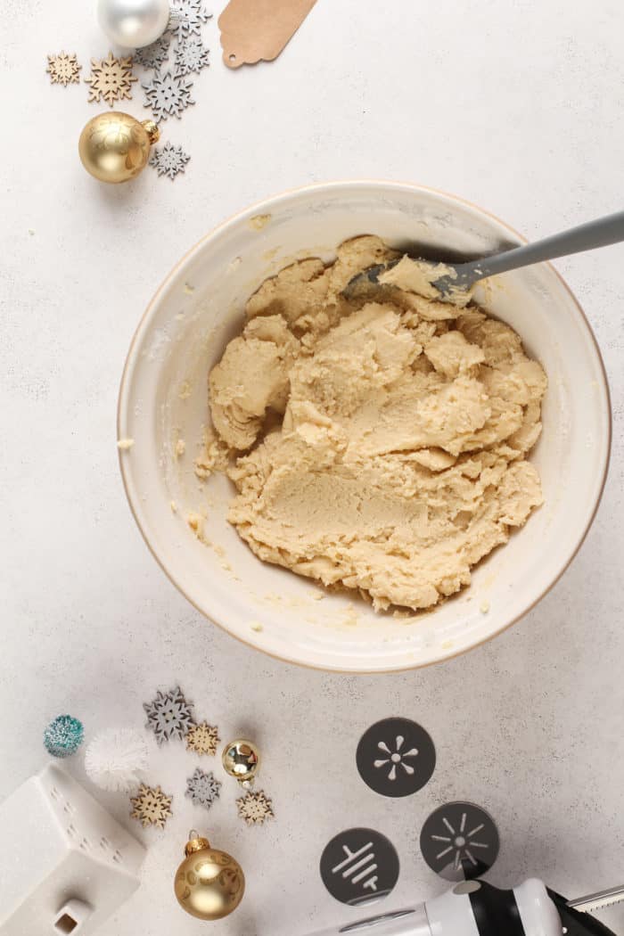 Spritz cookie dough in a ceramic mixing bowl.