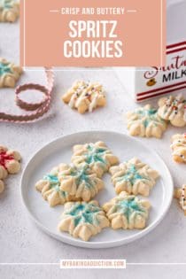 Small snowflake spritz cookies decorated with blue sanding sugar on a white plate. Text overlay includes recipe name.