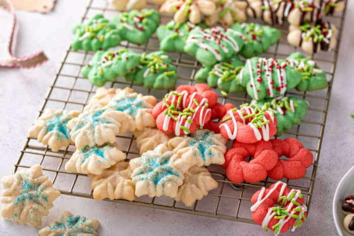 Assorted decorated spritz cookies on a wire cooling rack.