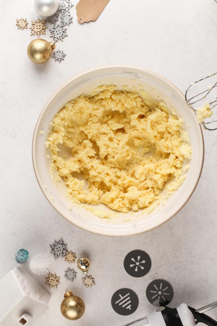 Wet ingredients for spritz cookie dough in a ceramic mixing bowl.