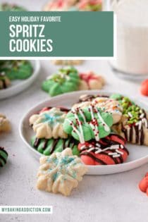 White plate with several spritz cookies. A small snowflake spritz cookie is leaning against the edge of the plate. Text overlay includes recipe name.