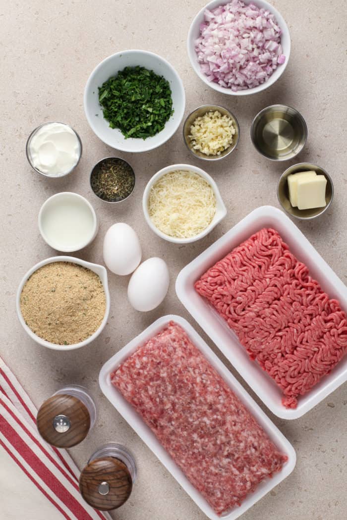 Ingredients for air fryer meatballs arranged on a beige countertop.