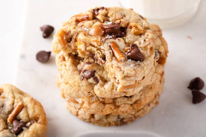 Kitchen sink cookie with a bite taken from it sitting on top of a stack of other kitchen sink cookies.