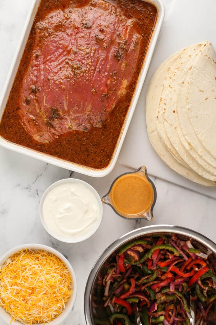 Components for chipotle quesadillas arranged on a marble countertop.