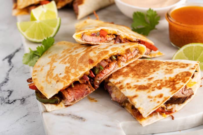 Three slices of chipotle quesdadillas arranged overlapping each other on a marble board.