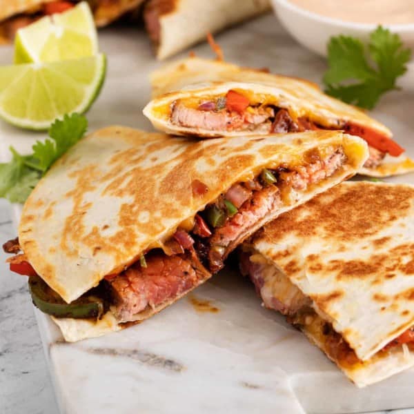 Slices of chipotle quesadillas arranged on a marble countertop.