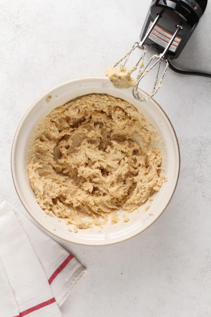 Wet ingredients for kitchen sink cookies in a ceramic mixing bowl.