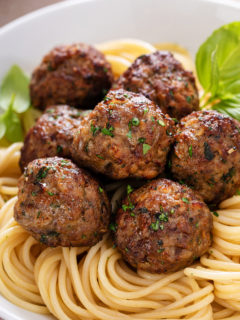 Air fryer meatballs on top of a bed of spaghetti.