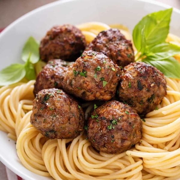 Air fryer meatballs on top of a bed of spaghetti.